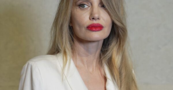 H Angelina Jolie συμπλήρωσε το λευκό σατέν φόρεμά της με έντονο κόκκινο κραγιόν