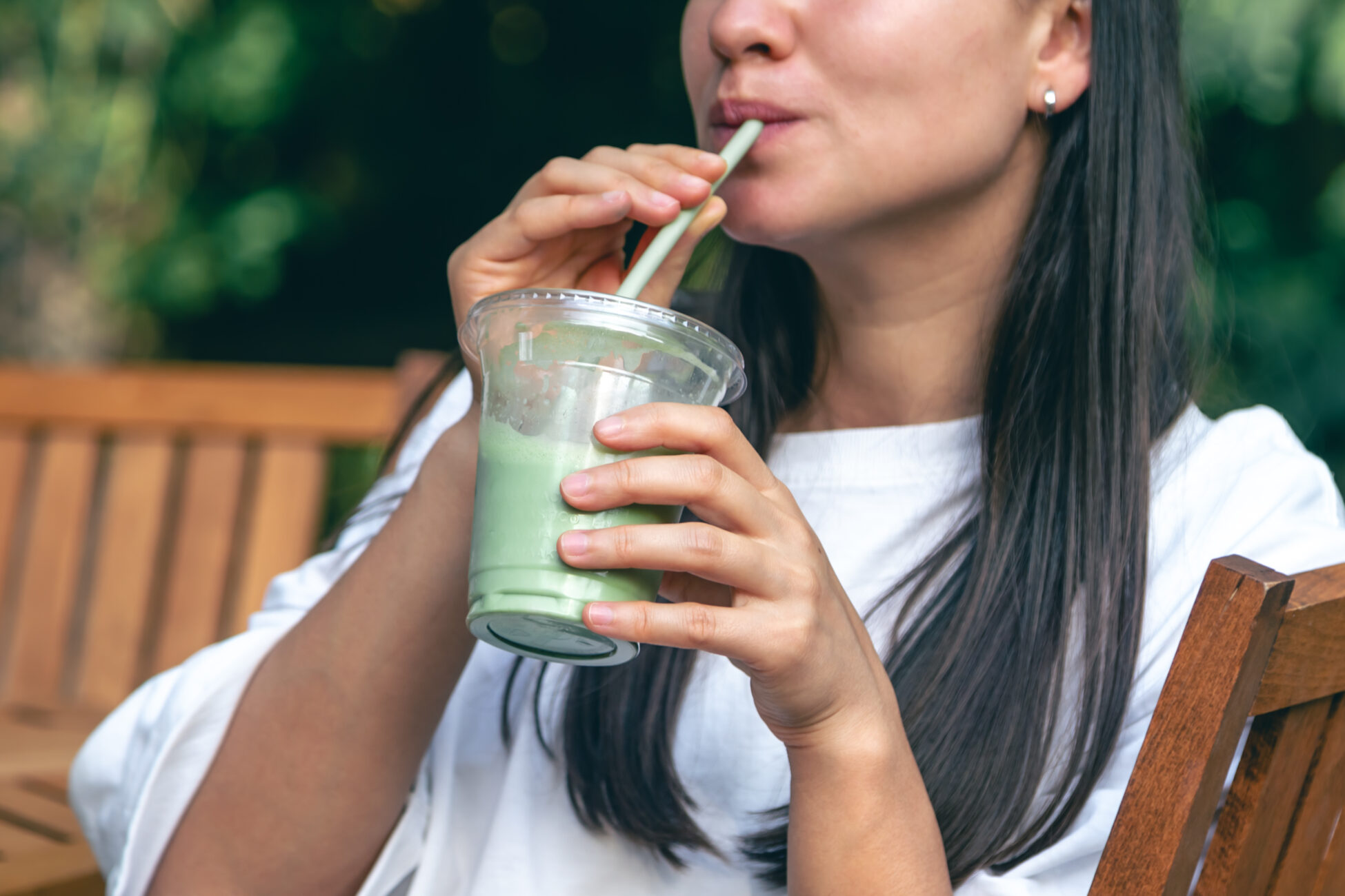 Woman drinking matcha latte, healthy iced drink.